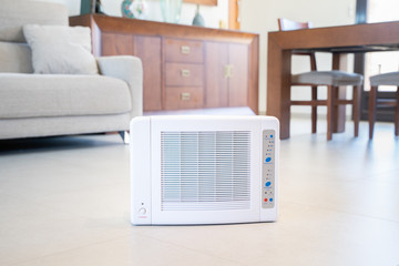 Ozone machine generator inside the living room floor. Home cleaning and disinfection during covid 19 epidemic. Domestic safety equipment.