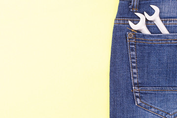 Poster - Wrenches in a craftsman jeans pocket on a yellow background with place for text