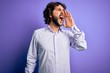 © Krakenimages.com - Young handsome business man with beard wearing shirt standing over purple background shouting and screaming loud to side with hand on mouth. Communication concept.