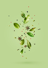 Creative Mockup With Flying Various Types Of Spices Bay Leaf, Red Pepper, Anise On Green Background With Copy Space.