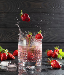 Wall Mural - Fresh strawberry cocktail with ripe strawberries and ice cubes.Splash of strawberry cocktail.