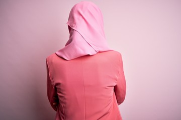 Canvas Print - Young beautiful girl wearing muslim hijab standing over isolated pink background standing backwards looking away with crossed arms