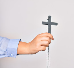 Hand of caucasian young catholic woman holding christian cross over isolated white background