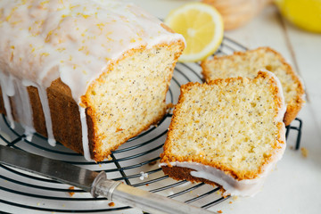 Glazed lemon pound cake loaf with poppy seed on cooling rack