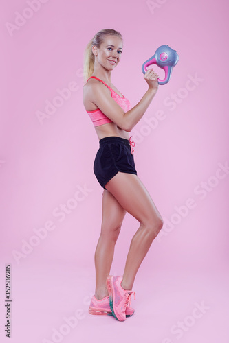 Fotografía Sexy sporty lady with weight studio portrait on pink background, fitness sporty woman beautiful fit girl, weight loss