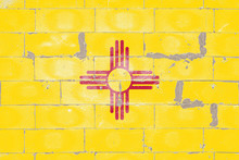 National Flag Of US State Of New Mexico, The Red Sun Sign, Zia Symbol, Yellow On Independence Day, Against A Background Of A Brick Wall With Peeling Paint. Political And Religious Disputes, Delivery.