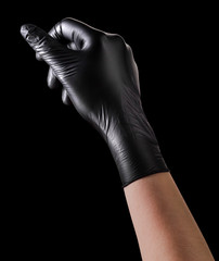 Wall Mural - Hand in black glove holding something isolated on black background