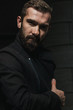 © Daria - Stylish and successful bearded manager posing outdoors in a brown coat and looking in camera. Low key portrait.