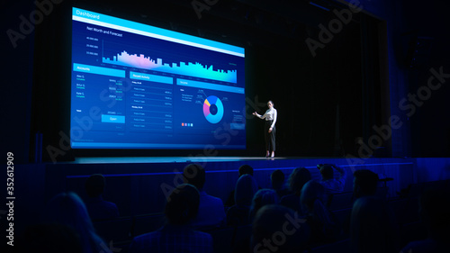 Business Forum Economics Conference Stage: Visionary Female Chief Analyst Delivers Speech and Shows Infographics, Statistics on Movie Theater Screen Tableau sur Toile