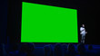 © Gorodenkoff - Software Startup Founder Does Presentation of New Product to the Audience, Behind Him Movie Theater with Green Screen, Mock-up, Chroma Key. Business Conference Live Event or Device Reveal