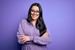 © Krakenimages.com - Young brunette woman wearing glasses over purple isolated background happy face smiling with crossed arms looking at the camera. Positive person.