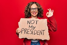 Middle Age Woman Asking For Democracy Holding Banner With Not My President Message Doing Ok Sign With Fingers, Smiling Friendly Gesturing Excellent Symbol