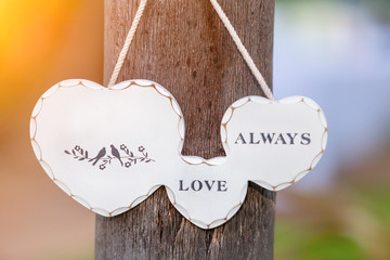 Wedding decoration of a garland of a heart hanging on a tree on a sunny day. Copy space