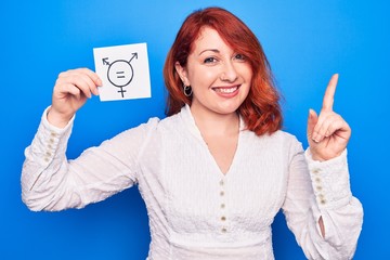 Sticker - Redhead woman asking for sex discrimination holding paper with transgender equality message smiling happy pointing with hand and finger to the side