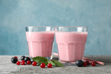 Wall Mural - Delicious berry milkshakes on gray table. Summer drink