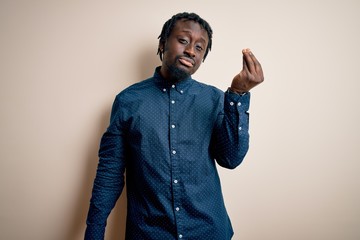 Sticker - Young handsome african american man wearing casual shirt standing over white background Doing Italian gesture with hand and fingers confident expression