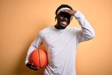 Sticker - Young african american sportsman doing sport holding basketball ball over yellow background stressed with hand on head, shocked with shame and surprise face, angry and frustrated. Fear and upset