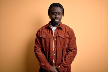 Canvas Print - Young handsome african american man wearing casual jacket standing over yellow background skeptic and nervous, frowning upset because of problem. Negative person.