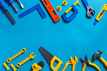 Toys background. Top view of toy tools on blue background