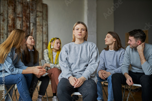 caucasian female alcohol addict is emotionally devastated, sit in the distance from anonymous alcoholics club, his first visit of therapy