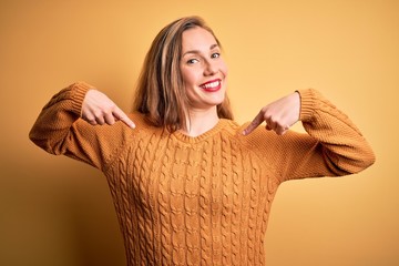 Sticker - Young beautiful blonde woman wearing casual sweater standing over yellow background looking confident with smile on face, pointing oneself with fingers proud and happy.