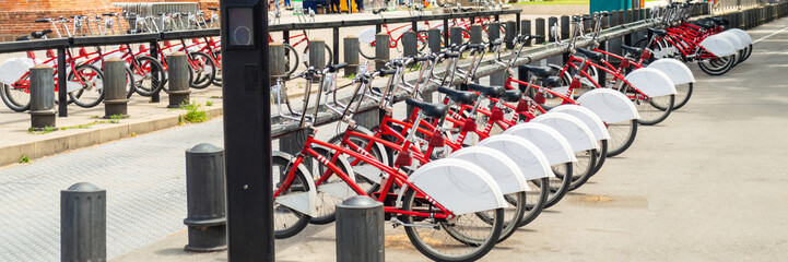 Many red bicycles for rent in european city