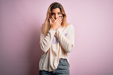 Poster - Young beautiful blonde woman wearing casual sweater standing over pink background shocked covering mouth with hands for mistake. Secret concept.