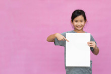 Little Asian Girl Holding White Paper Isolated On Pink Background.