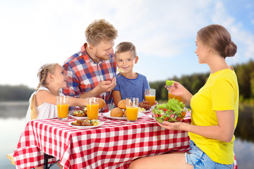 Canvas Print - Happy family having picnic at table in park