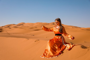 Wall Mural - A girl in a beautiful Moroccan dress. Merzouga Morocco.