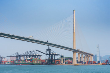 Cargo port and bridge in harbor of Hong Kong city