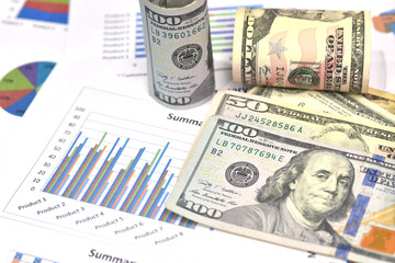 Exchange rate concept. Dollars bills and Diagram of stock market prices rates. One us dollar bills, rolled hundred us dollar bills. Ruler on the chart. Red and black lines on the graph.