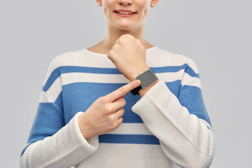 Wall Mural - technology and people concept - happy smiling teenage girl in pullover with smart watch over grey background