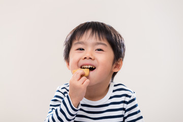 Asian kid boy eat cookie on white background