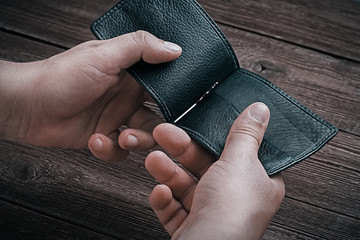 Closeup hands of a young man with an open empty wallet. Unemployment, financial crisis, bankruptcy, job and money loss concept