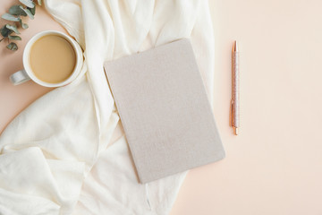 Fototapete - Flat lay composition with paper notebook, cup of coffee, blanket and pen on beige background. Elegant feminine workspace, home office desk concept.