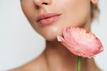 Cropped image of beautiful seductive shirtless woman posing with flower