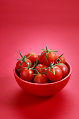 red cherry tomatoes on white marbel background on colorful red background