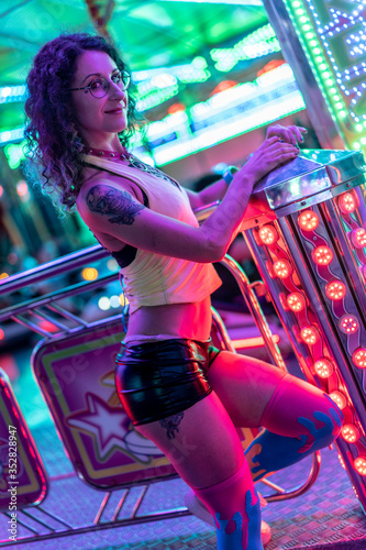 Fotografía a young woman in eighties clothes with curly hair posing in different attraction