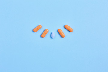 medicine creative concept. vitamins and pills to maintain healthy skin and hair. simple flat lay on a blue background