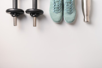 Wall Mural - Sport and fitness equipment, dumbbells, shoes, water bottle on grey. Top view, space for your text.