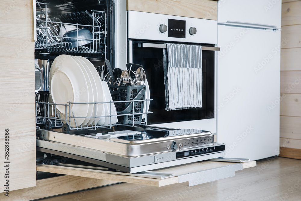 Open dishwasher with white clean dishes after washing in modern scandinavian kitchen. - obrazy, fototapety, plakaty 