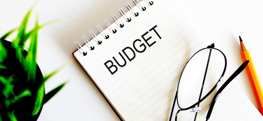 Poster - Notebook with glasses and pencil on white background, business concept Budget