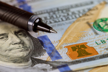 Wall Mural - Close-up pen and 100 US dollar bills background