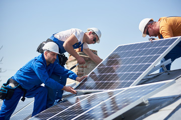 male team engineers installing stand-alone solar photovoltaic panel system. electricians mounting bl