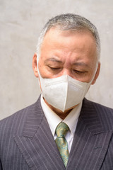 Sticker - Face of stressed mature Japanese businessman with mask thinking outdoors