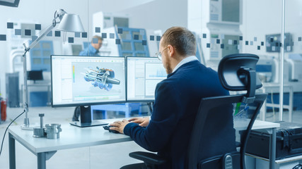 Poster - Industrial Engineer Working on a Personal Computer, Two Monitor Screens Show CAD Software with 3D Prototype of Hybrid Electric Engine and Charts. Working Modern Factory.