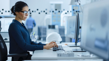 Poster - Beautiful Female Engineer Working on Personal Computer in the High-Tech Industrial Factory, She Uses CAD Software to Model Heavy Industry High Tech Mechanism 3D Model. Side View Shot