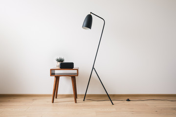 Wall Mural - metal floor lamp and wooden coffee table with plant and clock with blank screen