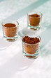Three small glasses full of the chocolate powder for cooking